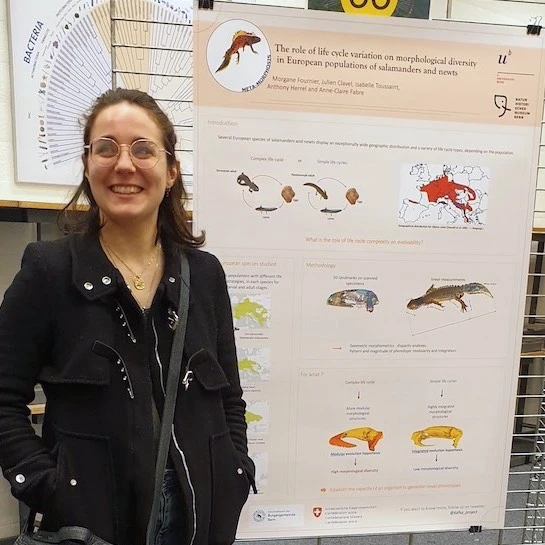 A person standing in front of their poster at a science conference